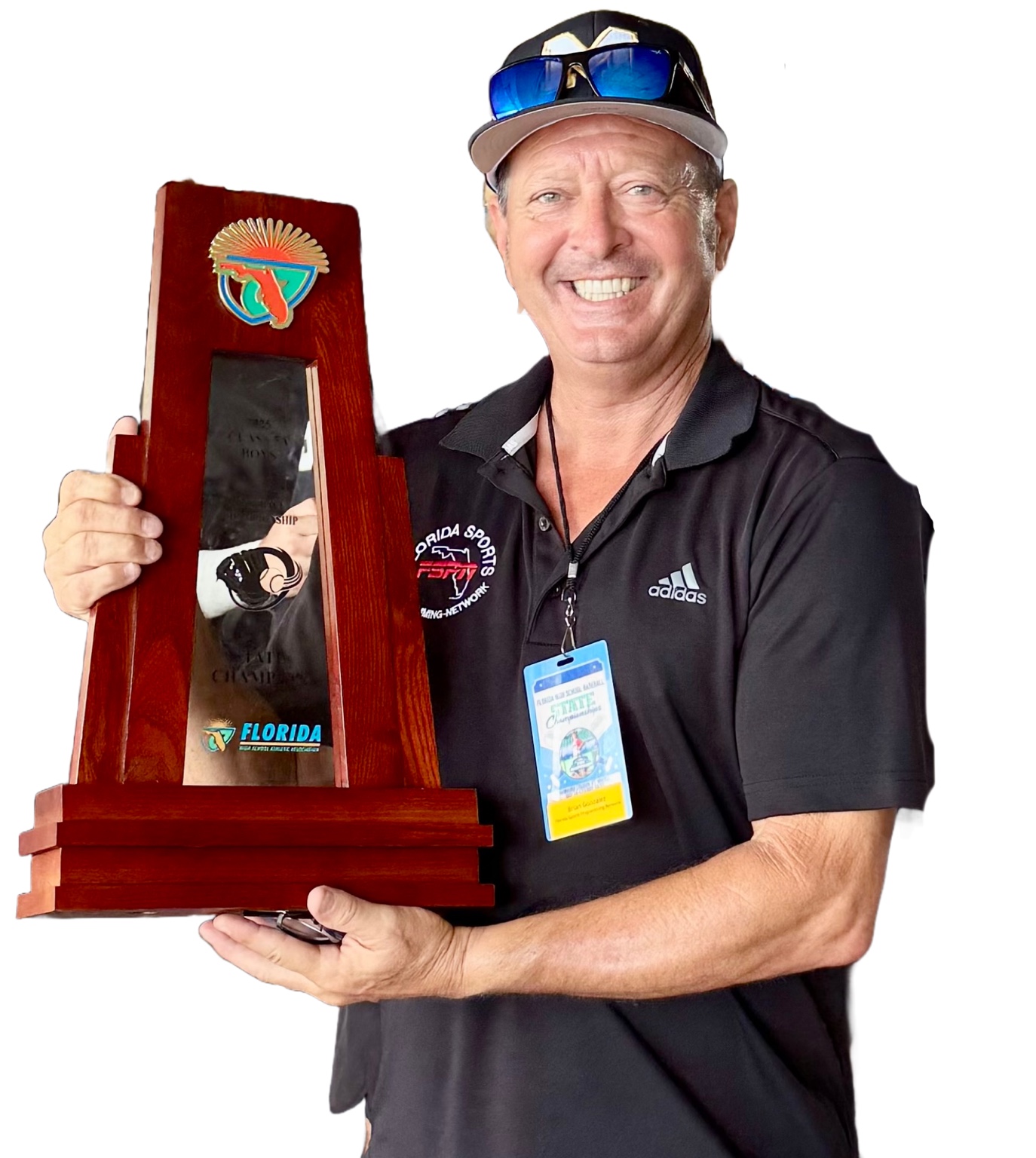 Brian Uncle Mugs Gonzalez holding a Florida championship trophy and wearing an event credential